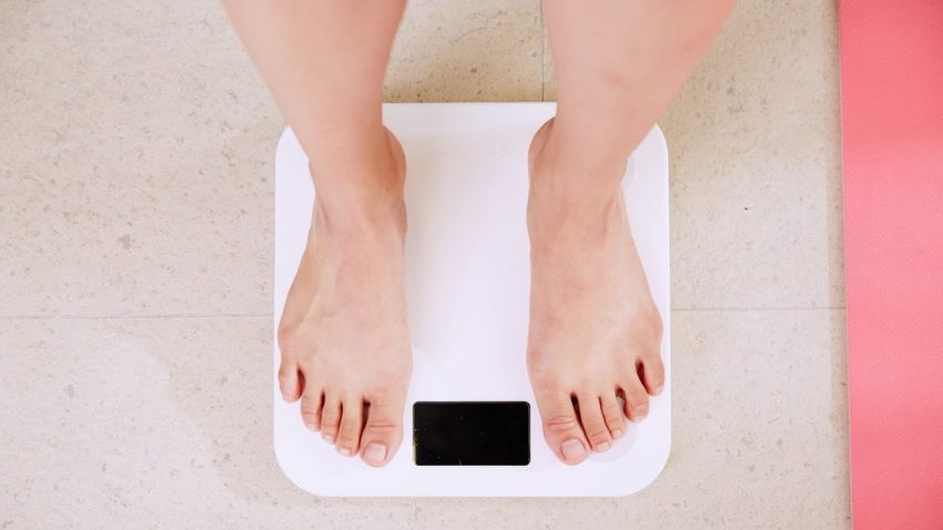 person standing on white digital bathroom scale